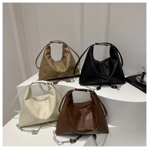 Detail of four PU leather tote bags showing irregular stitching texture and chain straps