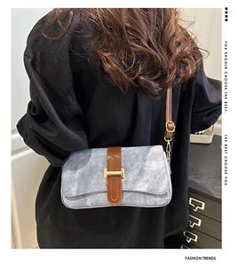 Détail du sac à bandoulière bleu avec garniture en cuir brun et fermoir en H doré