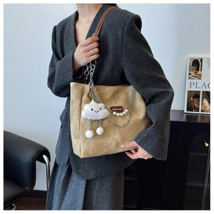 Detail of khaki corduroy tote bag with silver chain, pearls, and cloud charm