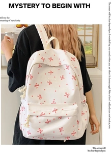 Detail eines weißen Segeltuchrucksacks mit roten Schleifenprints und Modeschild