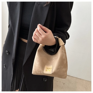 Detail showing vintage textured beige tote bag with MIAO SHO leather logo patch