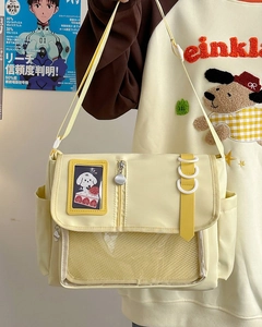 Detail of light yellow canvas ita bag showing transparent mesh pocket and adjustable strap