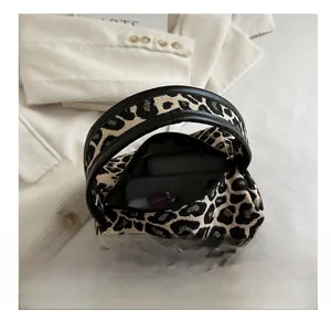 Macro shot of leopard print mini tote bag interior showing phone storage capacity