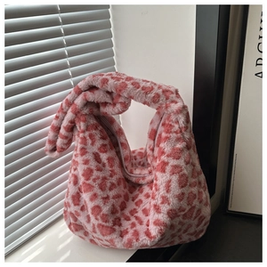 Détail du sac à main en fausse fourrure léopard rose avec texture douce et zip