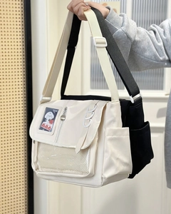 Close-up of black and beige messenger bags with transparent PVC card windows and pockets