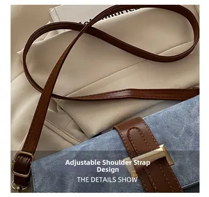 Détail macro de la bandoulière réglable en cuir marron avec boucle H dorée sur sac denim
