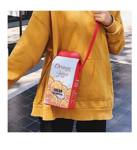 Détail d'un sac bandoulière amusant en forme de brique de jus d'orange avec sangle