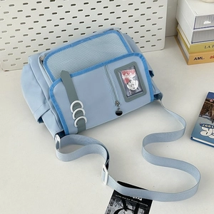 Detailed close-up of light blue messenger bag with transparent pocket and mesh window