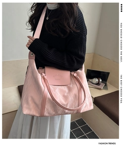 Detailed view of pink high-capacity travel tote with unique pleated texture and wide strap