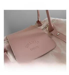 Detail of pink marble pattern travel bag with HUAJIAO FASHION logo and gold zipper