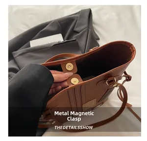 Detail view of the magnetic metal buckle and premium brown PU leather on this tote bag
