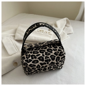 Detailed view of the leopard print mini handbag with zipper and black handles