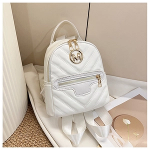 Detail of white quilted mini backpack featuring gold M logo and adjustable straps