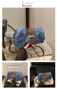 Vue détaillée du sac à bandoulière bleu foncé avec finitions en cuir brun et boucle dorée