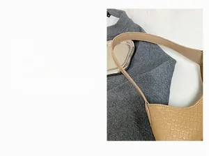 Detail view of the wide shoulder strap and woven texture on a beige tote bag