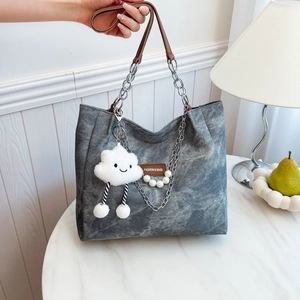 Grey denim tote bag with leather chain strap and cloud plush charm for women