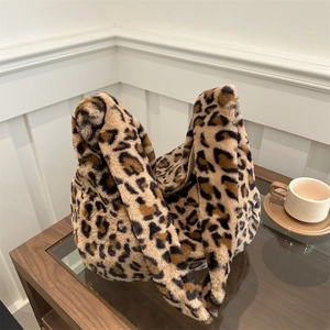 Sac à épaule en peluche léopard avec doubles poignées et fermeture éclair sur table