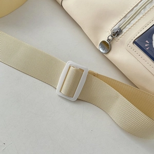 Detail of adjustable shoulder strap and clear PVC window on cream canvas ita bag