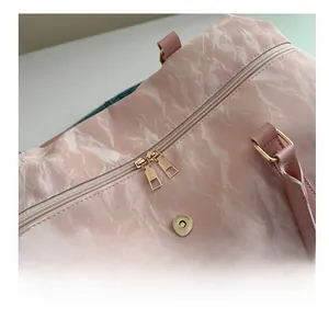 Close-up of pink marble pattern travel bag with premium gold dual zippers and leather handle