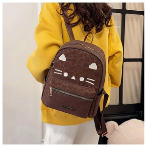 Close-up of leopard print details and cat embroidery on a vintage brown backpack