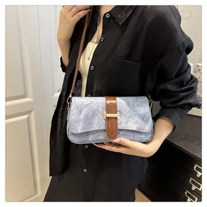 Vue détaillée du sac bandoulière bleu clair avec sangle en cuir marron et boucle en H dorée