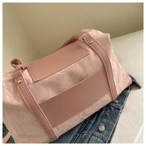 Detail of pink travel bag showing marble texture fabric and gold metal rivets