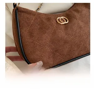 Close-up of brown suede hobo bag featuring quilted diamond pattern and gold metal buckle