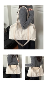 Detailed close-up of large off-white travel bag with ruffled texture and leather handle