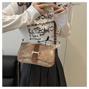 Détail du sac bandoulière vintage avec texture mate et boucle métallique dorée en forme de H