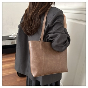 Vue détaillée d'un sac cabas en cuir marron montrant les fines lanières et la texture