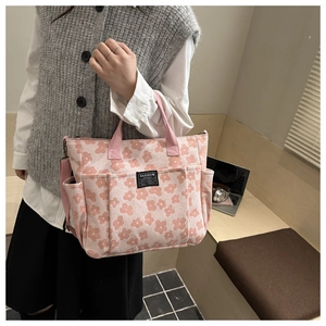 Detailed view of pink floral canvas tote bag with multiple pockets and adjustable shoulder strap