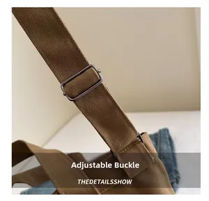 Detail of thick cotton canvas shoulder strap with adjustable silver metal buckle on brown tote
