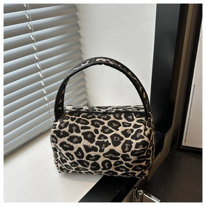 Detailed view of leopard print mini pillow bag with textured fabric and leather handle