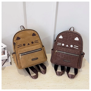 Detail view of ginger and brown cat-themed backpacks with cute embroidery and velvet texture