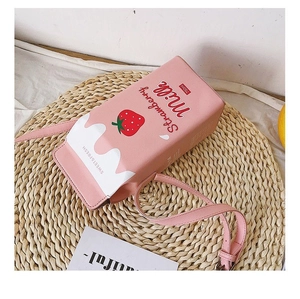 Détail du sac bandoulière boîte de lait rose avec imprimé fraise sur sous-verre tressé