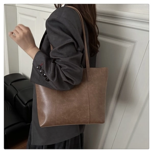 Détail d'un sac cabas marron rétro avec texture mate et coutures décoratives verticales