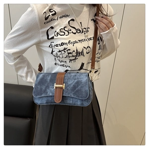 Mannequin portant un sac à rabat en jean bleu foncé avec bandoulière en cuir marron