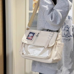 Detail of a beige canvas messenger bag featuring cute puppy patch and mesh pocket details