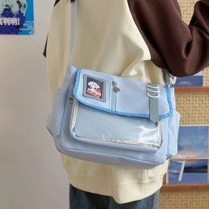 Detail of light blue crossbody messenger bag with clear zip pocket and cute puppy patch