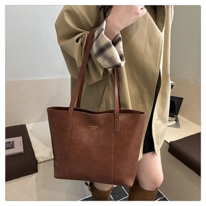 Détail d'un sac cabas rétro en cuir marron de grande capacité avec lettrage élégant