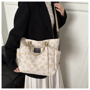 Detail showing the floral jacquard fabric and exterior side pockets of this canvas tote bag