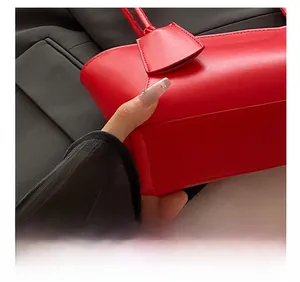 Detail showing precise stitching on the bottom of a matte red vintage tote bag