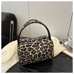 Detail view of stylish leopard print mini bag with smooth black top handles and silver zipper