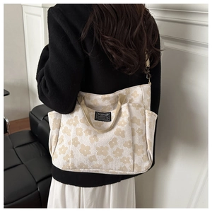 Detail of floral canvas tote bag featuring multi-pocket design and adjustable strap