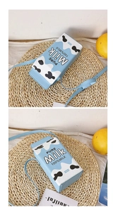 Détail d'un sac bandoulière boîte à lait bleu avec motif vache et logo Pure Milk