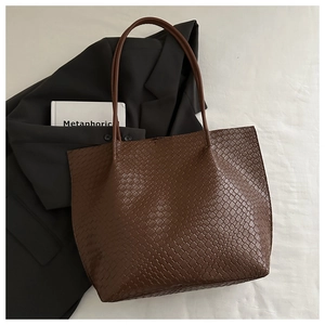 Brown woven tote bag with classic checkerboard texture shown in a professional lifestyle setting