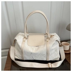 Close-up of cream white duffel bag with crinkle texture fabric and leather strap details