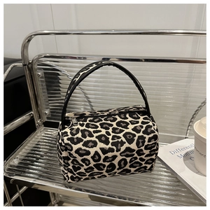 Detail of leopard print fabric texture and glossy round handle on a mini tote bag