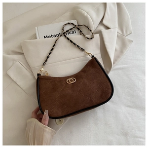 Detailed close-up of brown suede hobo bag with gold logo and quilted stitch texture