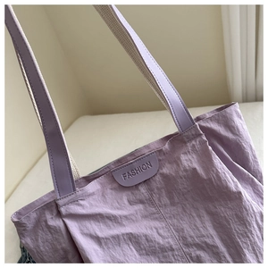 Détail du sac cabas en nylon violet avec étiquette en cuir Fashion et bandoulière robuste
